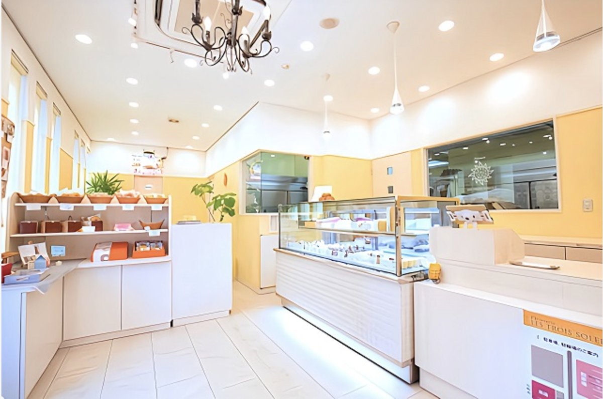パティスリー レ・トロワ・ソレイユの店内。白と黄色を基調にした明るい空間にショーケースが並ぶ