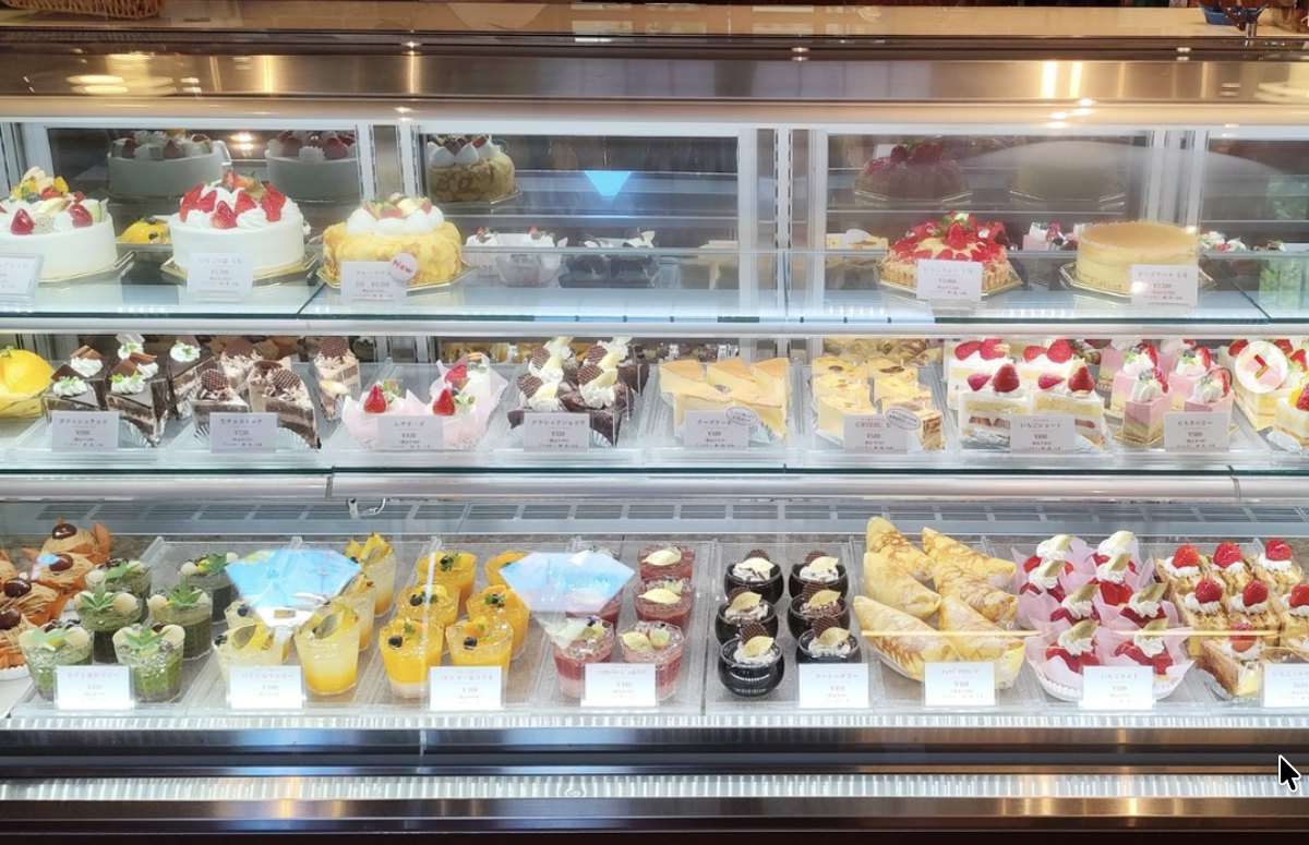 菓志工房うすながの店内ショーケース。上段にホールケーキ、中段に生ケーキ、下段にカップデザートが並ぶ